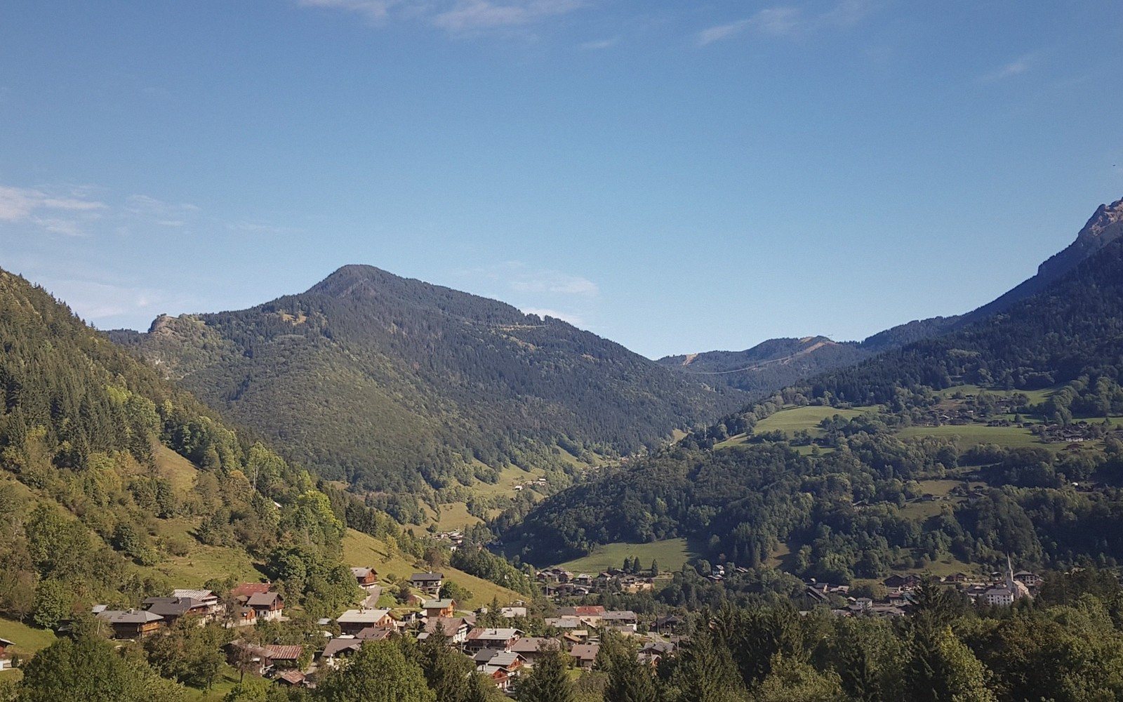 A chalet village with the valley below